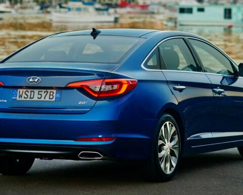 Blauer Hyundai Sonata von hinten an einer Uferstraße.