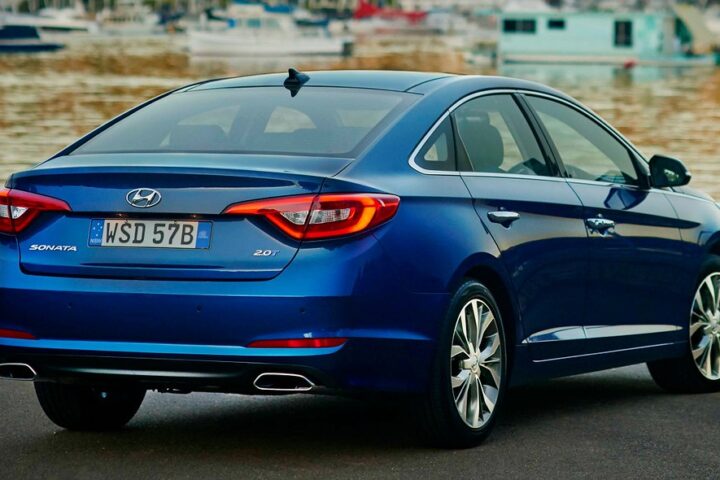Blauer Hyundai Sonata von hinten an einer Uferstraße.