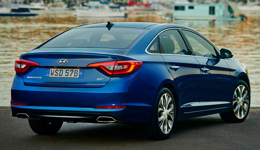 Blauer Hyundai Sonata von hinten an einer Uferstraße.