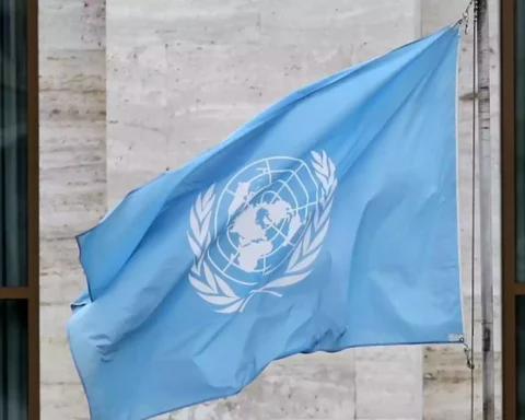 Blaue Flagge der Vereinten Nationen vor einem Gebäude.