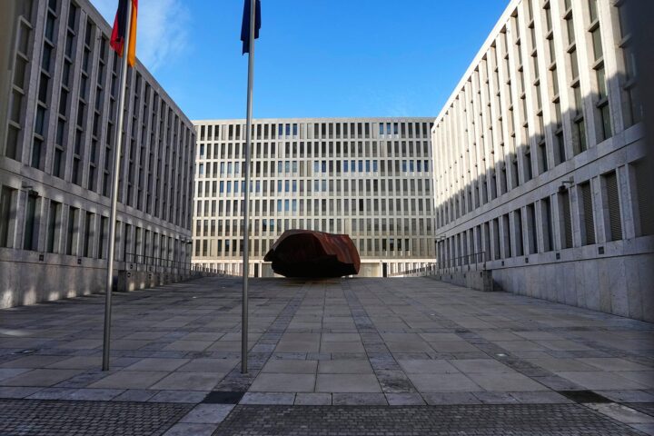 Blick in den Innenhof des Bundesnachrichtendienstes mit Fahnenmasten und moderner Gebäudefassade.