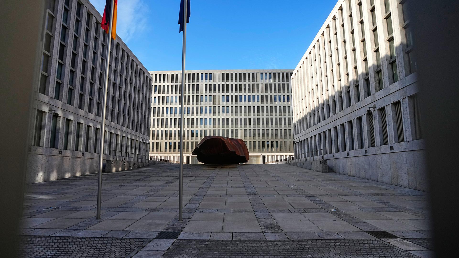 Blick in den Innenhof des Bundesnachrichtendienstes mit Fahnenmasten und moderner Gebäudefassade.