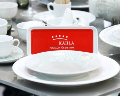 Kahla-Porzellan auf einem Tisch mit rot-weißem Markenlogo.