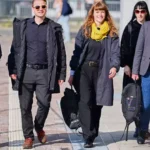 Mehrere Politiker gehen gemeinsam auf einem Gehweg im Freien.