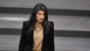 Eine Politikerin steht im Plenarsaal vor einem grauen Hintergrund.