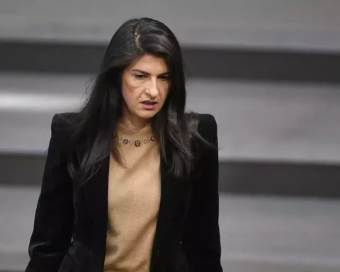 Eine Politikerin steht im Plenarsaal vor einem grauen Hintergrund.