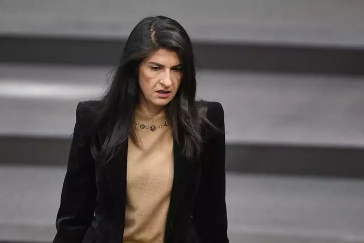 Eine Politikerin steht im Plenarsaal vor einem grauen Hintergrund.