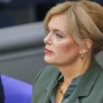 Julia Klöckner sitzt in einer Sitzung und blickt zur Seite.