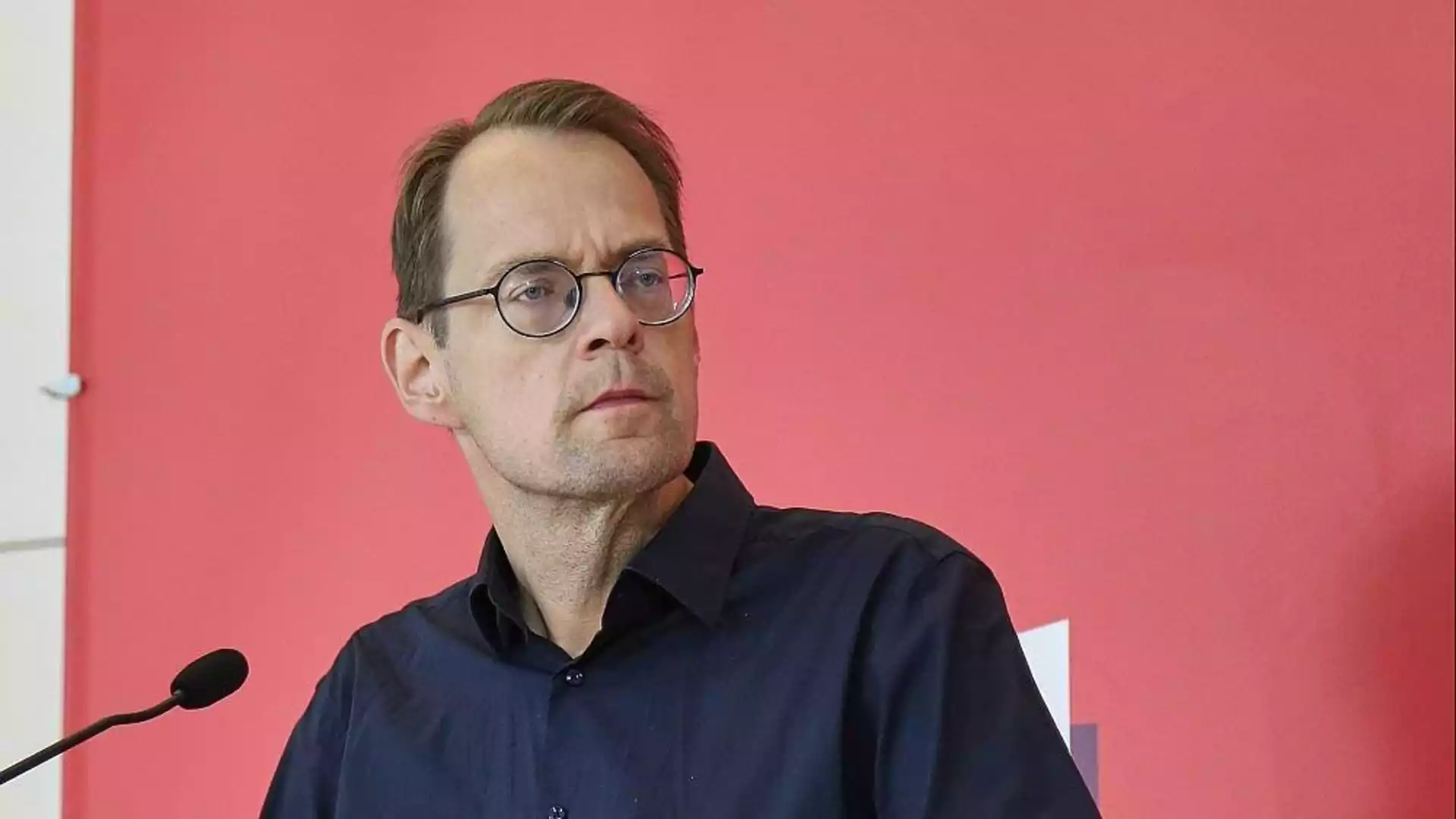 Pellmann fordert Merz nach Wahl von Rausch zum Handeln auf 1 Ein Mann mit Brille steht vor einem Mikrofon vor rosafarbenem Hintergrund.