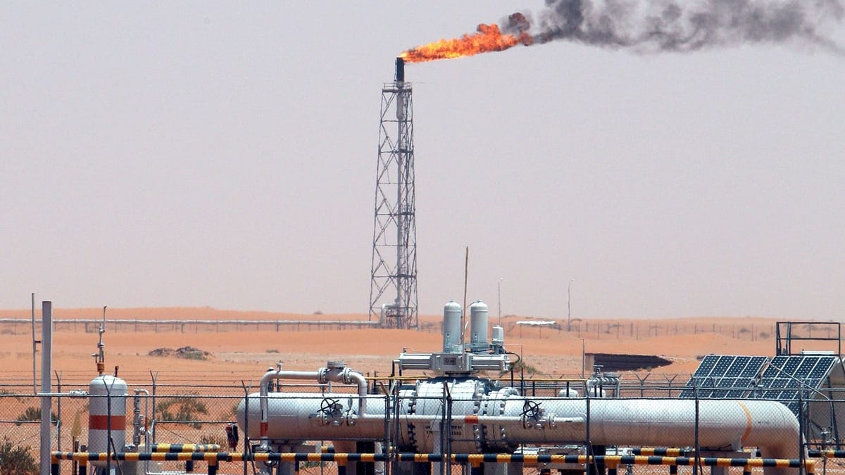 Gasfackel auf einer Industrieanlage in der Wüste mit Rohrleitungen im Vordergrund.