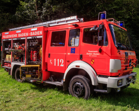 Rotes Feuerwehrfahrzeug der Feuerwehr Baden-Baden auf einer Wiese im Wald.