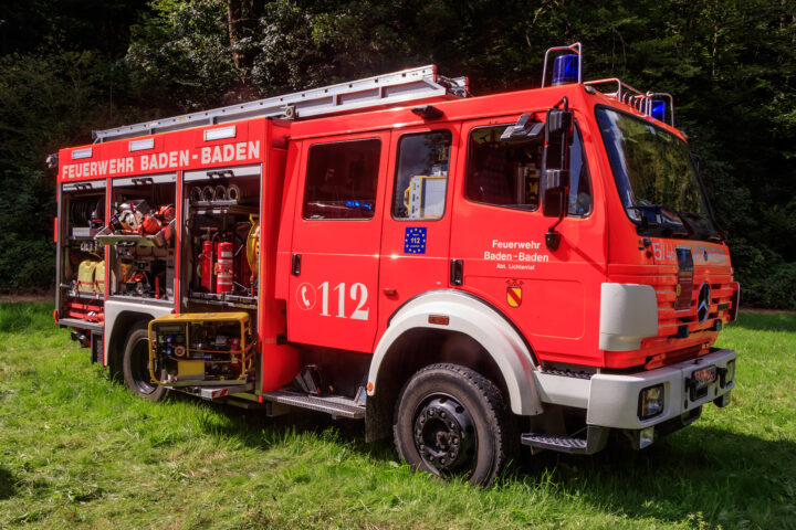 Rotes Feuerwehrfahrzeug der Feuerwehr Baden-Baden auf einer Wiese im Wald.