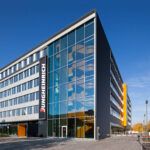 Jungheinrich-Gebäude mit Glasfassade und Firmenlogo bei klarem Himmel.