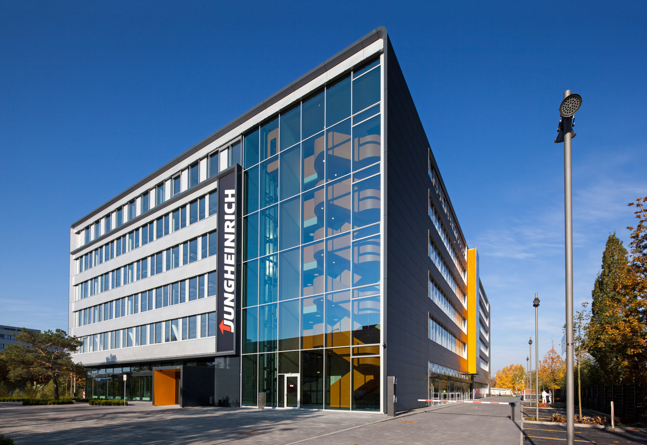 Jungheinrich-Gebäude mit Glasfassade und Firmenlogo bei klarem Himmel.