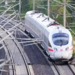 Ein ICE der Deutschen Bahn fährt auf einer elektrifizierten Bahnstrecke unter zahlreichen Oberleitungen.