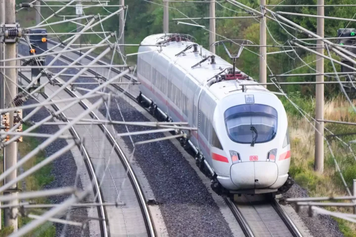 Ein ICE der Deutschen Bahn fährt auf einer elektrifizierten Bahnstrecke unter zahlreichen Oberleitungen.