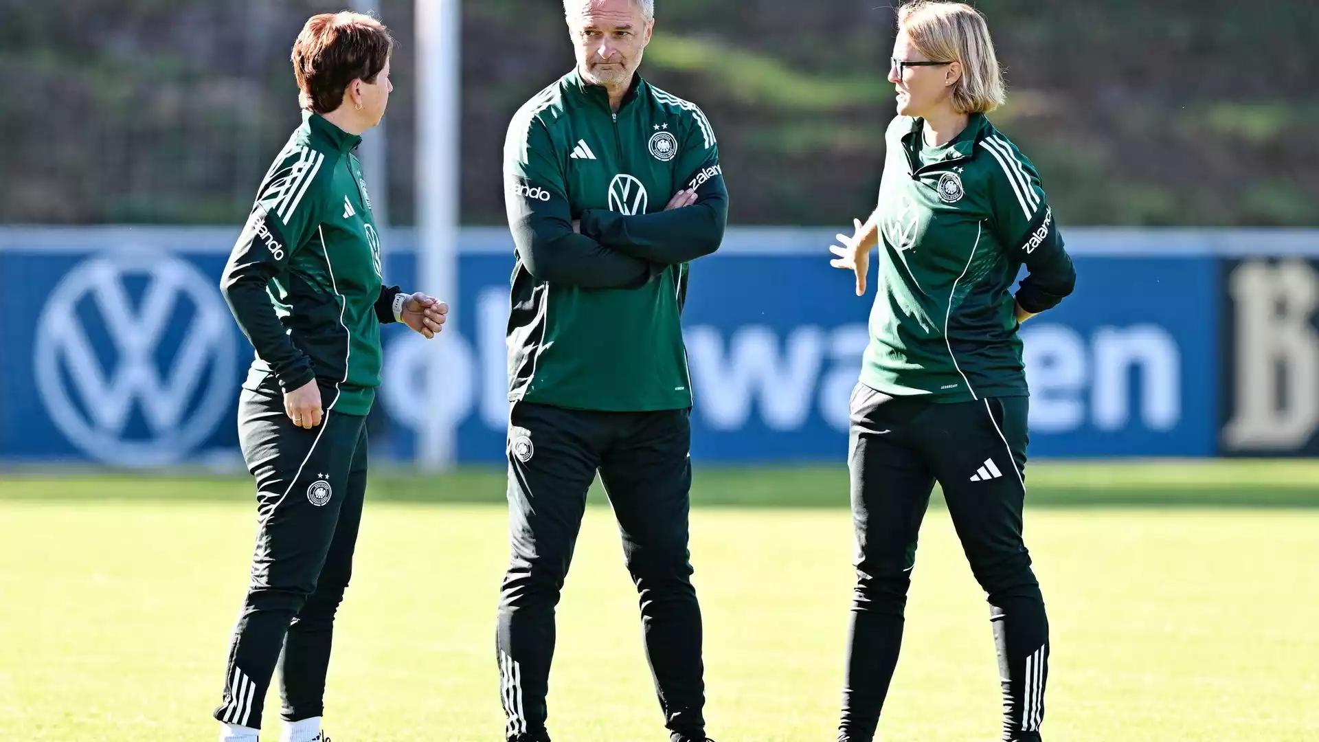 Wück erweitert den Kader der DFB-Frauen vor Spielen gegen Australien und Japan 1 Christian Wück spricht mit zwei Trainerinnen auf einem Fußballtrainingsplatz.