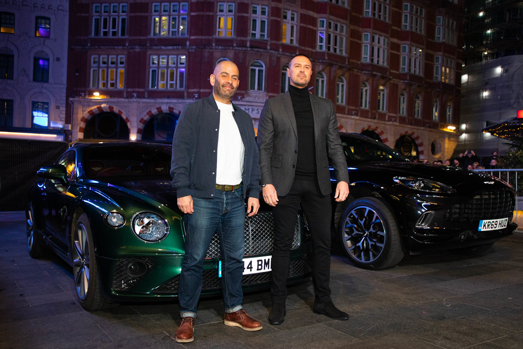 Bernstein Research stuft Continental auf „Outperform“ hoch und hebt Kursziel an 1 Zwei Männer stehen nachts vor zwei Luxusautos bei einer Veranstaltung.