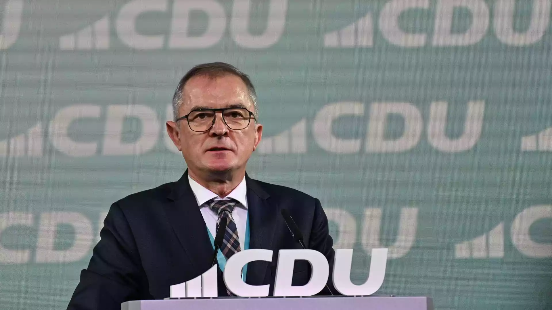 Marco Tullner spricht an einem CDU-Pult vor einem Hintergrund mit CDU-Logo.