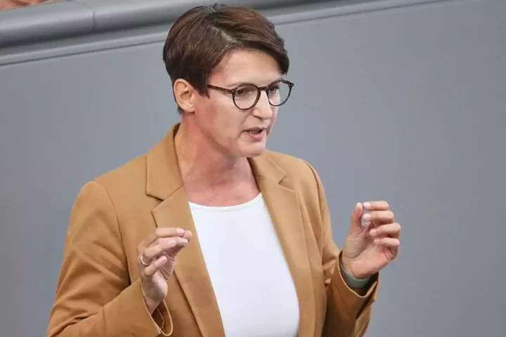 Eine Frau mit Brille spricht im Plenarsaal und gestikuliert mit beiden Händen.
