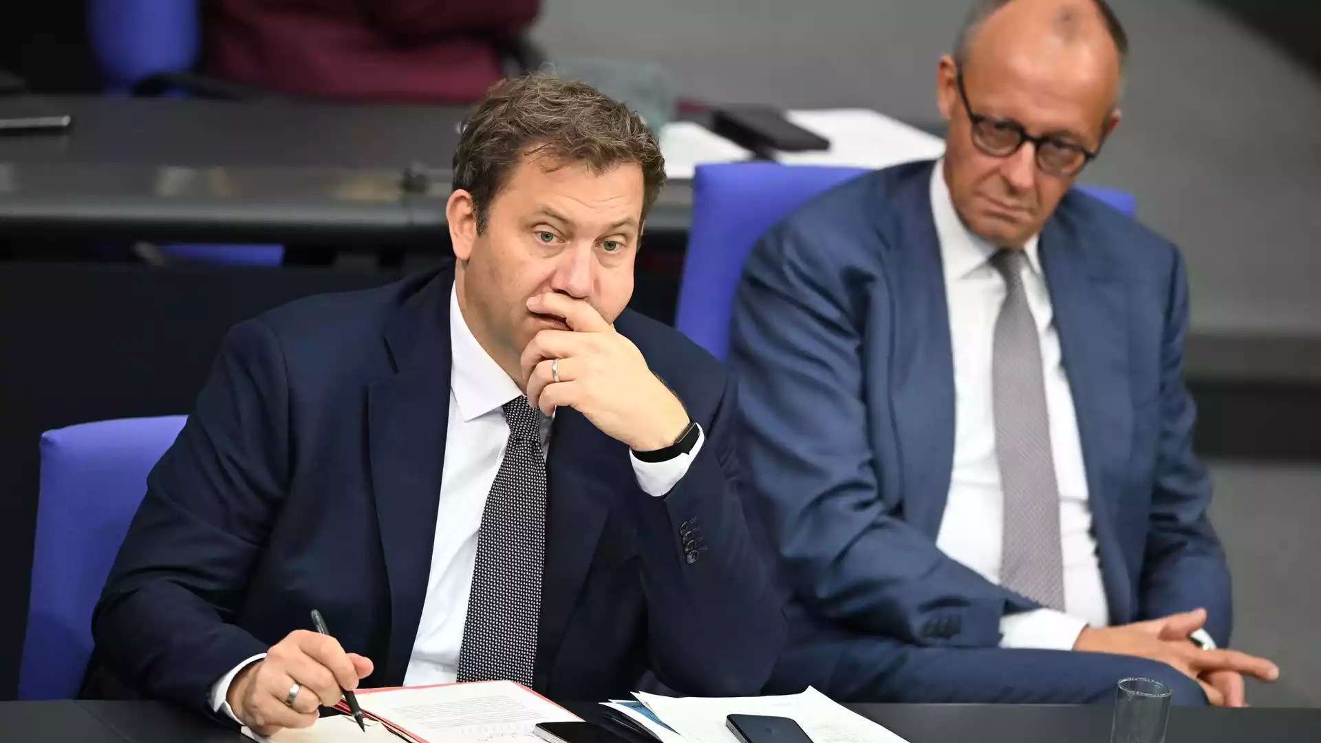 Koalitionsausschuss warnt vor Extremismus und bleibt bei Reformzeitplan vage 1 Zwei Politiker sitzen bei einer Besprechung an einem Tisch, einer macht sich Notizen und wirkt nachdenklich.