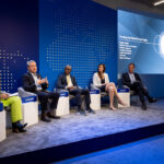 Mehrere Personen sitzen auf einer Bühne bei einer Paneldiskussion vor blauem Hintergrund mit PepsiCo-Bezug.