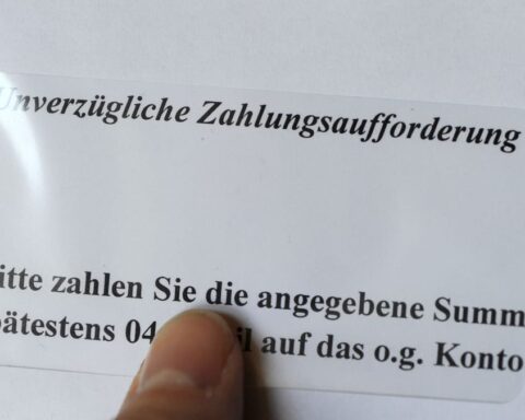 Finger zeigt auf eine deutsche Zahlungsaufforderung mit dem Hinweis „Unverzügliche Zahlungsaufforderung“.