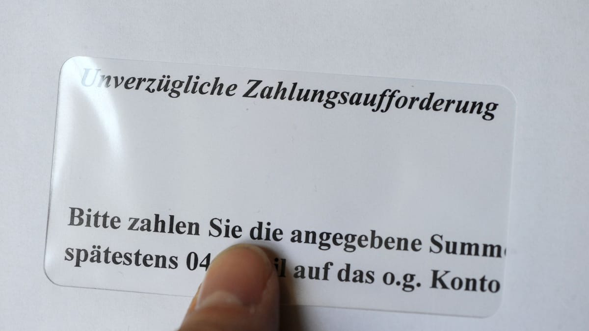 Finger zeigt auf eine deutsche Zahlungsaufforderung mit dem Hinweis „Unverzügliche Zahlungsaufforderung“.
