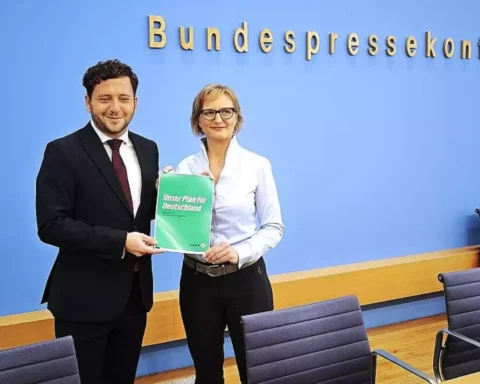 Felix Banaszak und Franziska Brantner halten einen Grünen-Antrag vor der Wand der Bundespressekonferenz.
