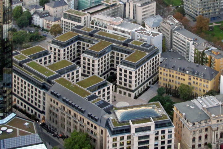 Luftaufnahme eines modernen Gebäudekomplexes mit begrünten Dächern; am unteren Bildrand ist ein Crédit-Agricole-Gebäude zu sehen.