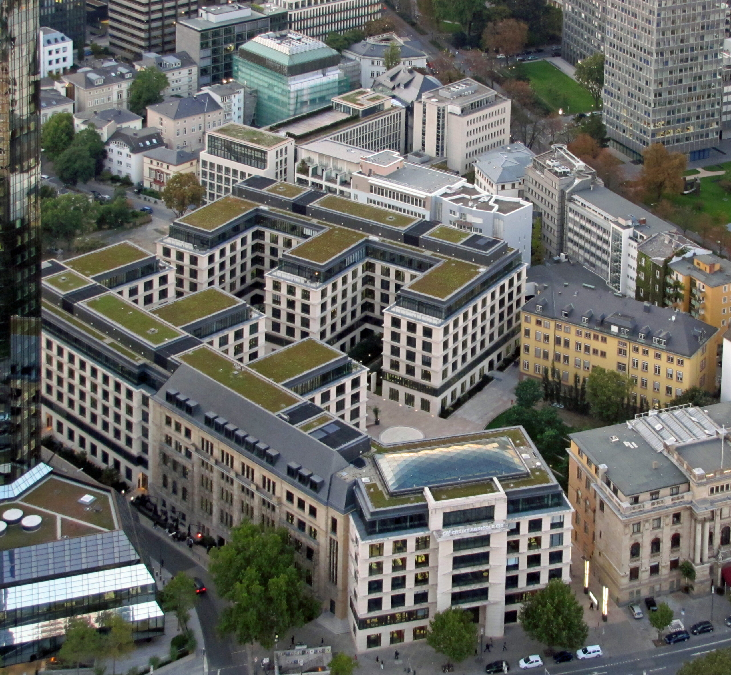 Crédit Agricole will in Deutschland Privatkunden-Angebote bis Ende Oktober starten 1 Luftaufnahme eines modernen Gebäudekomplexes mit begrünten Dächern; am unteren Bildrand ist ein Crédit-Agricole-Gebäude zu sehen.