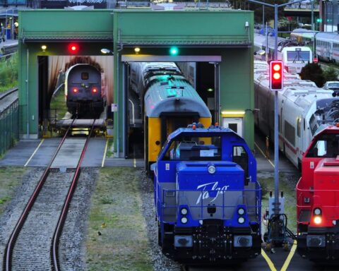 Mehrere Lokomotiven stehen in einem Bahndepot vor einer Waschanlage und auf Gleisen.