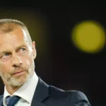 Aleksander Čeferin im dunklen Anzug vor unscharfem Hintergrund.