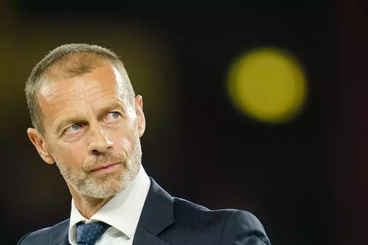 Aleksander Čeferin im dunklen Anzug vor unscharfem Hintergrund.