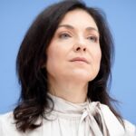 Katherina Reiche vor blauem Hintergrund.