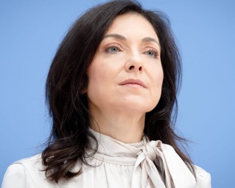 Katherina Reiche vor blauem Hintergrund.