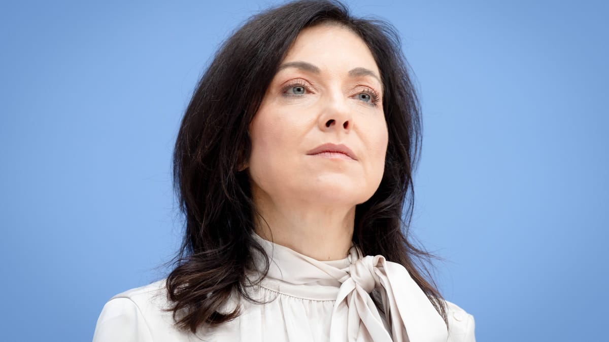 Katherina Reiche vor blauem Hintergrund.