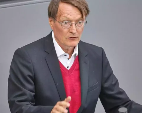Friedrich Merz spricht an einem Redepult vor grauem Hintergrund.