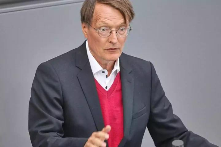 Friedrich Merz spricht an einem Redepult vor grauem Hintergrund.