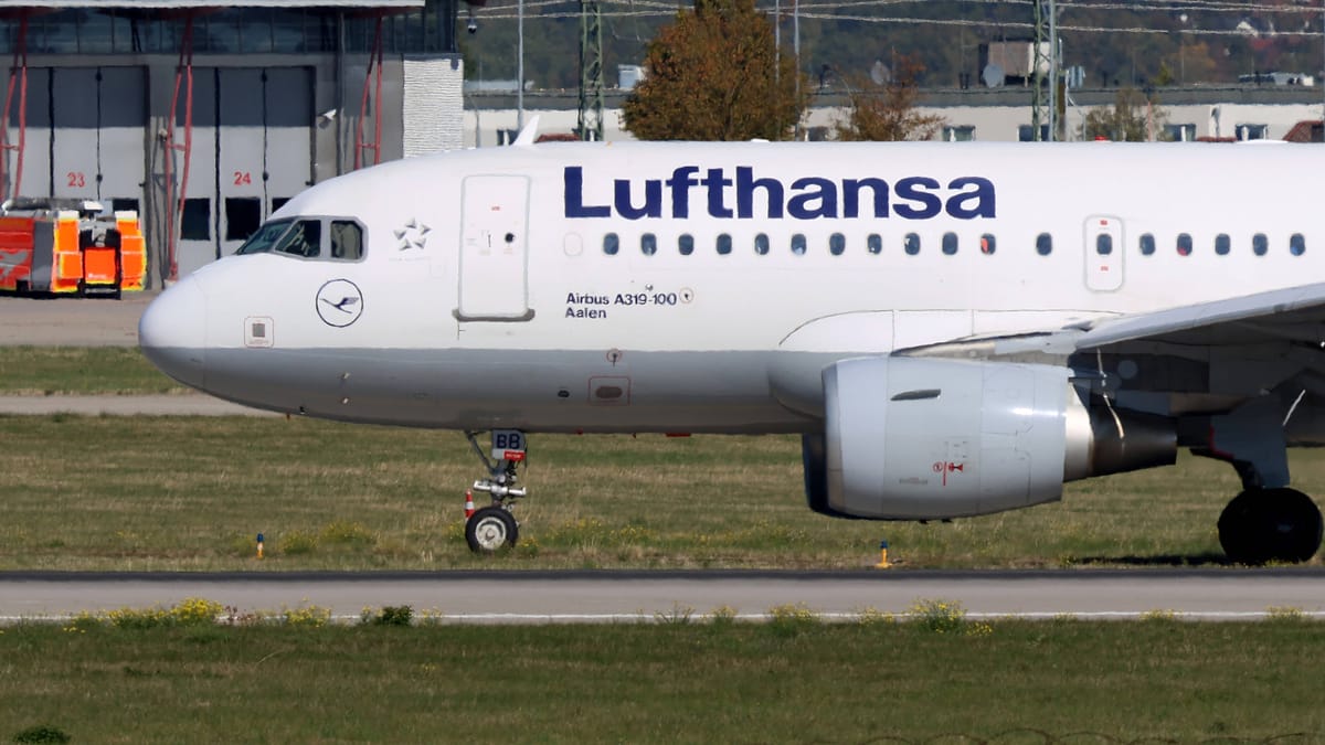 Eine Lufthansa-Maschine steht auf dem Rollfeld eines Flughafens.