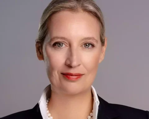 Porträt von Alice Weidel vor grauem Hintergrund.