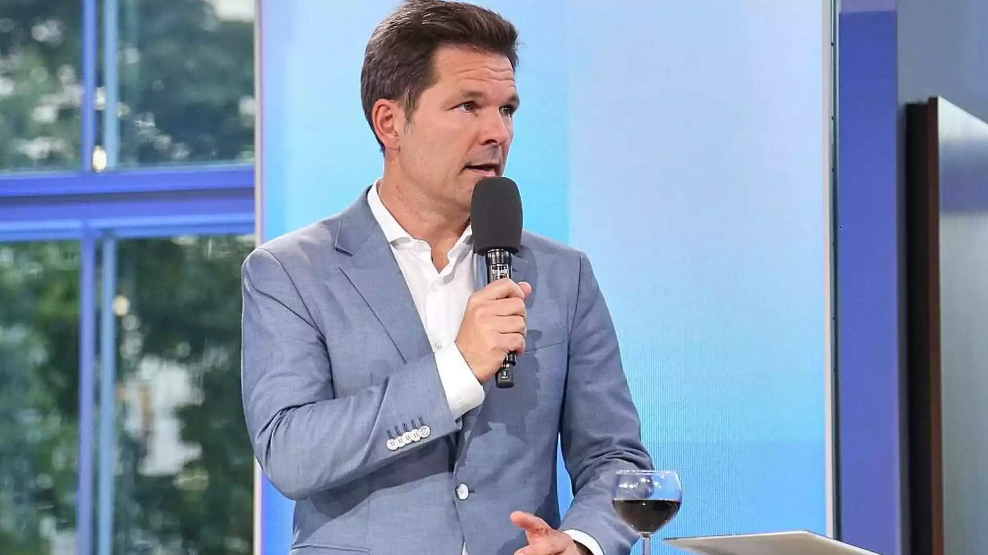 Steffen Krach spricht in einem Fernsehstudio in ein Mikrofon.