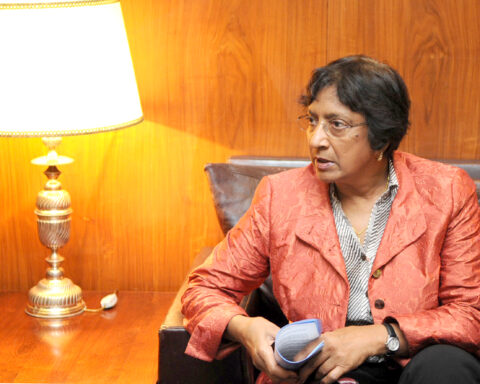 Navanethem Pillay sitzt in einem Sessel und hält Unterlagen in den Händen.