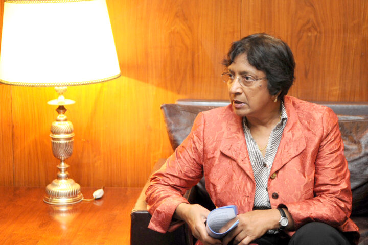 Navanethem Pillay sitzt in einem Sessel und hält Unterlagen in den Händen.