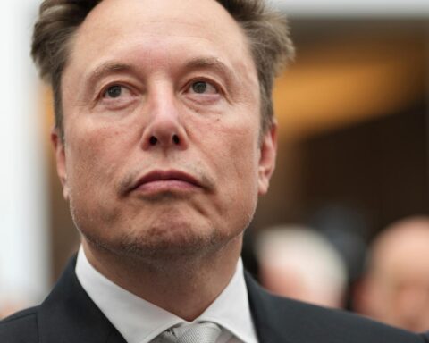 Elon Musk bei einem öffentlichen Auftritt in Anzug und Krawatte.
