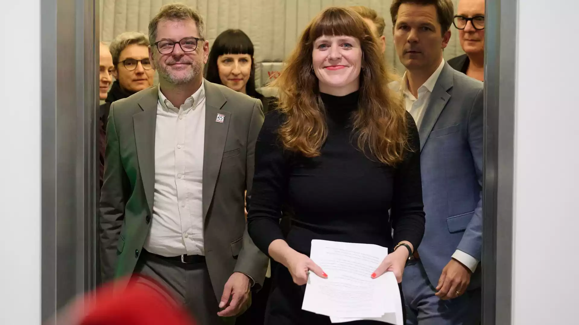 Linke, Grüne und SPD setzen Berliner Sondierungen fort 1 Mehrere Politikerinnen und Politiker stehen in einem Innenraum zusammen, eine Frau hält Papiere in der Hand.