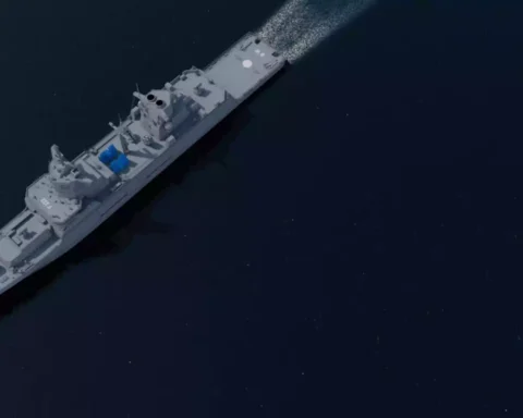 Luftansicht einer grauen Fregatte auf dunkler See mit sichtbaren Aufbauten und Decksbereichen.