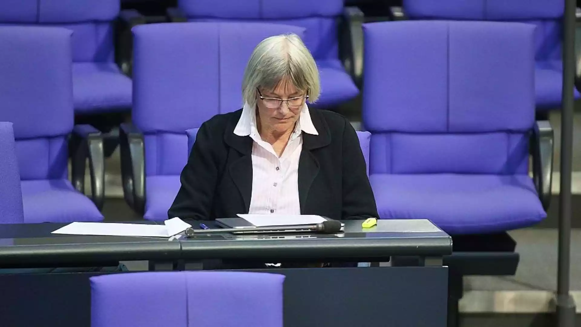Berliner Gericht weist Huy-Klage gegen DPG-Ausschluss ab 1 Eine Frau sitzt in einem parlamentarisch wirkenden Saal vor violetten Sitzen und blickt auf Unterlagen vor sich.