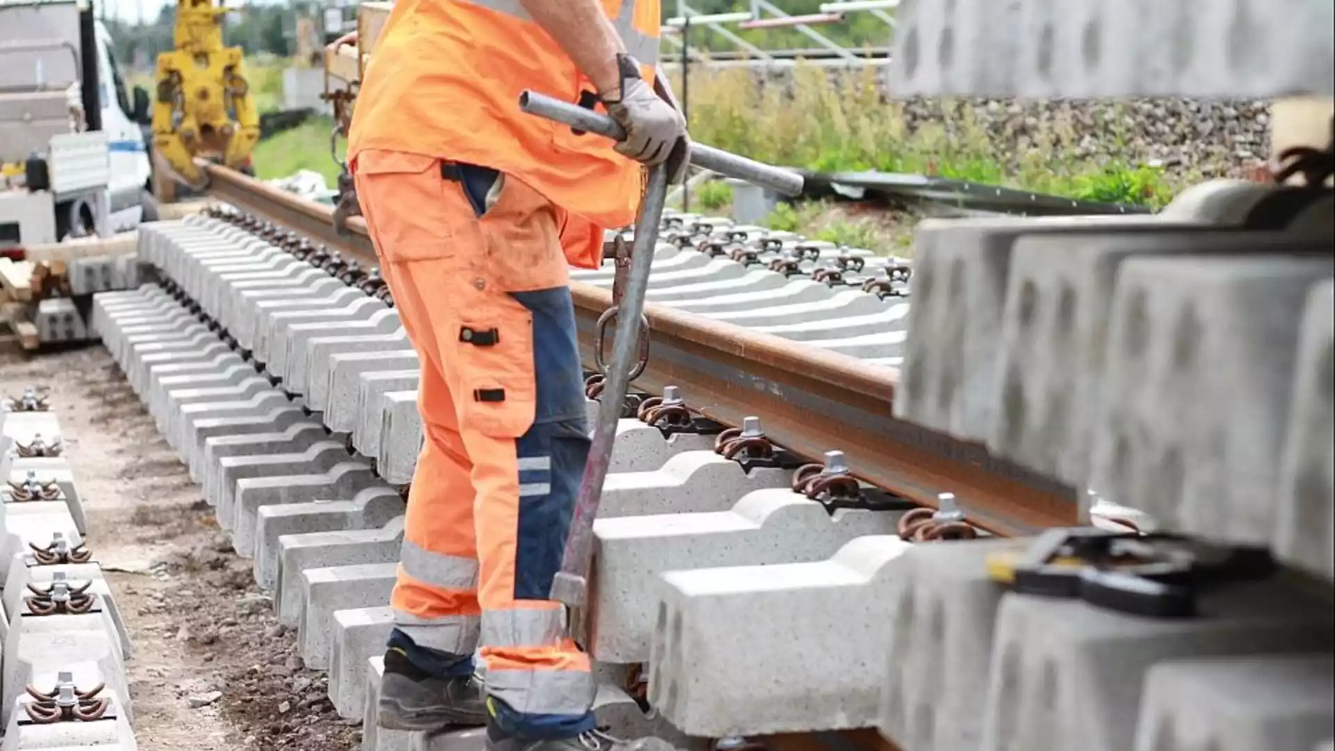 Union unterstützt Bilgers Plan zur gestreckten Korridorsanierung 1 Ein Arbeiter in orangefarbener Warnkleidung arbeitet an einem Gleis mit Betonschwellen und Schienen.