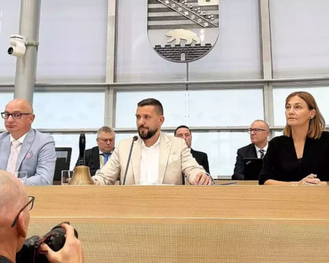 Mehrere Politiker sitzen an einem Sitzungstisch im Landtag, im Hintergrund das Wappen von Sachsen-Anhalt.